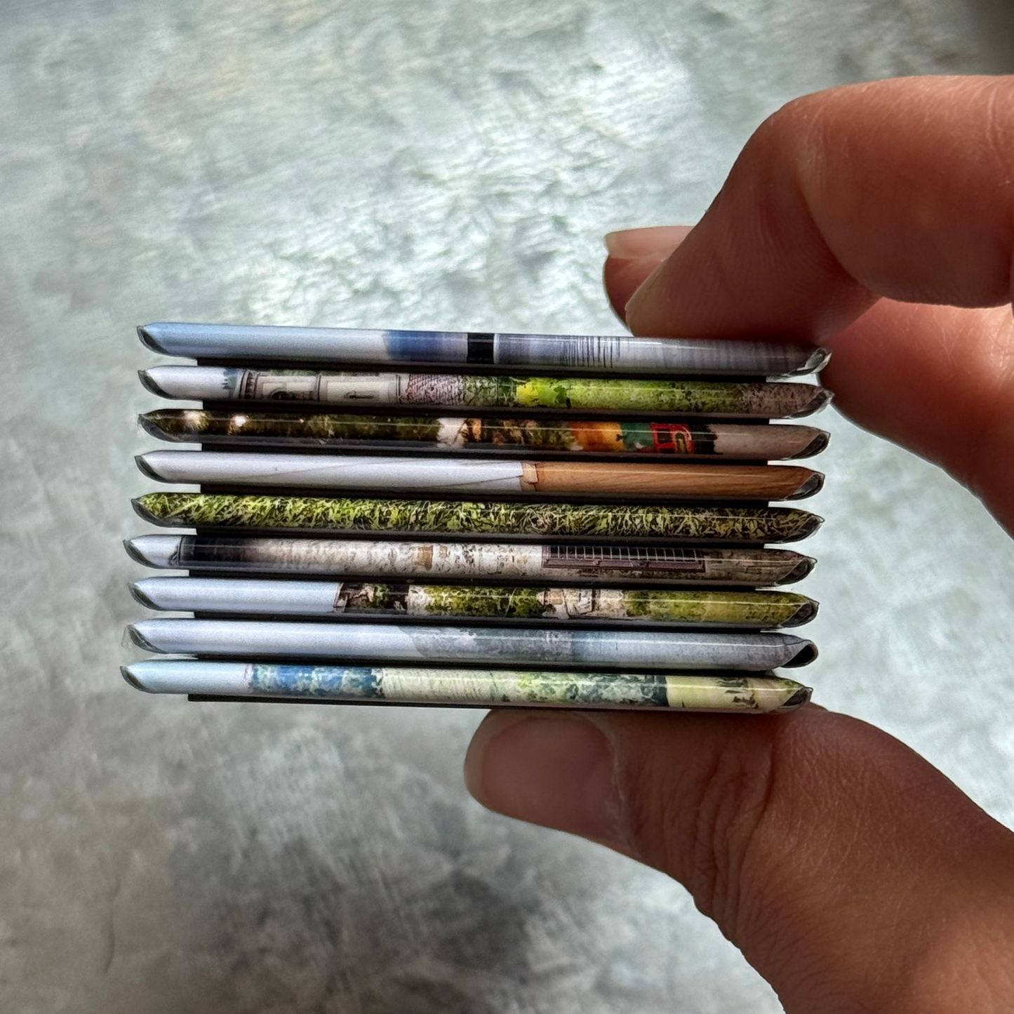 Hand holding a 2x2 handmade photo magnet to show size and smooth finish – Magnetic Momma product detai